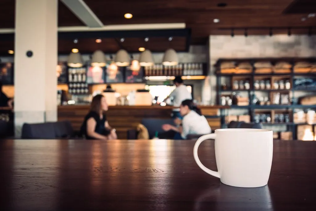 white mug of coffee in a coffee shop. coffee shops are an essential stop during a 3 days in seattle itinerary