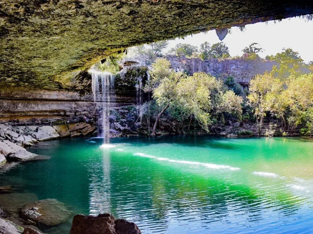 Hamilton Pool Preserve in Dripping Springs Texas with waterfall visible on the left side of the photo