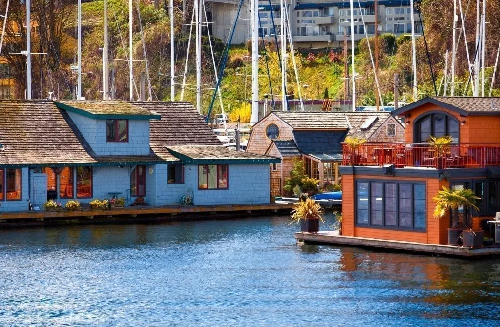 Houseboats on the water in Seattle WA with sailboats visible behind them--a beautiful sight you'll experience many times during this 3 day Seattle itinerary