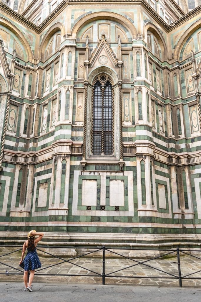 kate storm in a blue dress looking up at the back of the florence cathedral