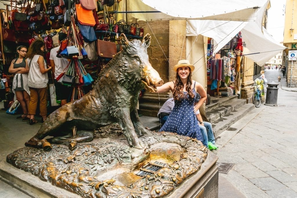 Kate Storm in a blue polka dot dress rubbing the nose of the porcellino in Florence--don't to rub his nose so this won't be your last 2 days in Florence Italy!