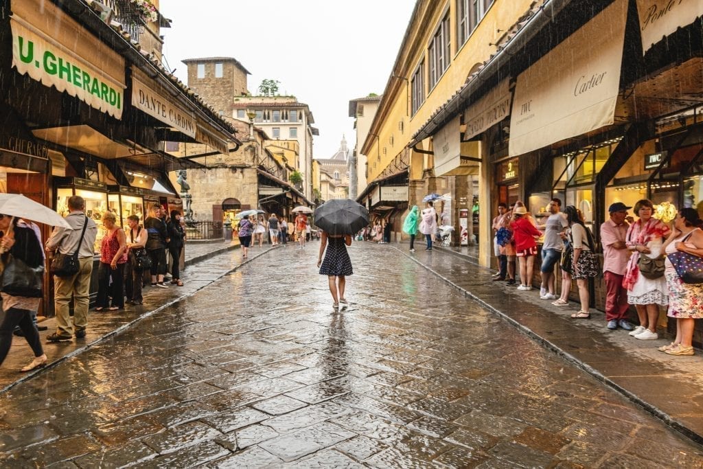 kate storm walking across the ponte vecchio in the rain in florence italy