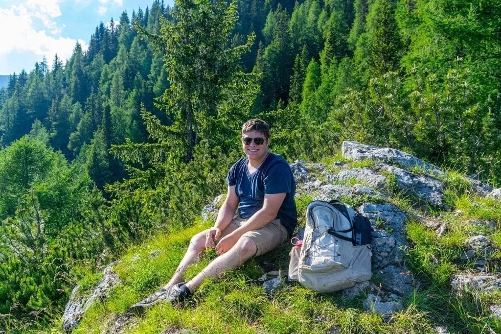 Jeremy Storm sitting on a forested trail in Slovenia