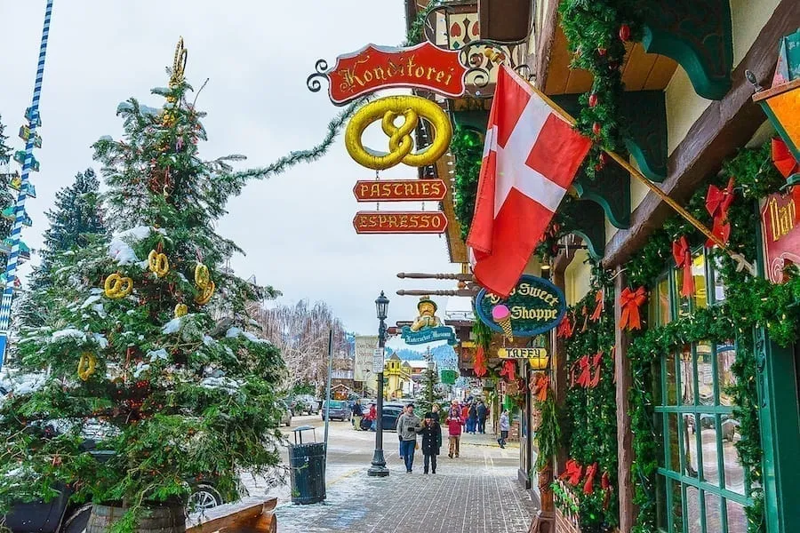 Small street in Leavenworth Washington decorated for Christmas, with a Christmas tree on the left side of the photo