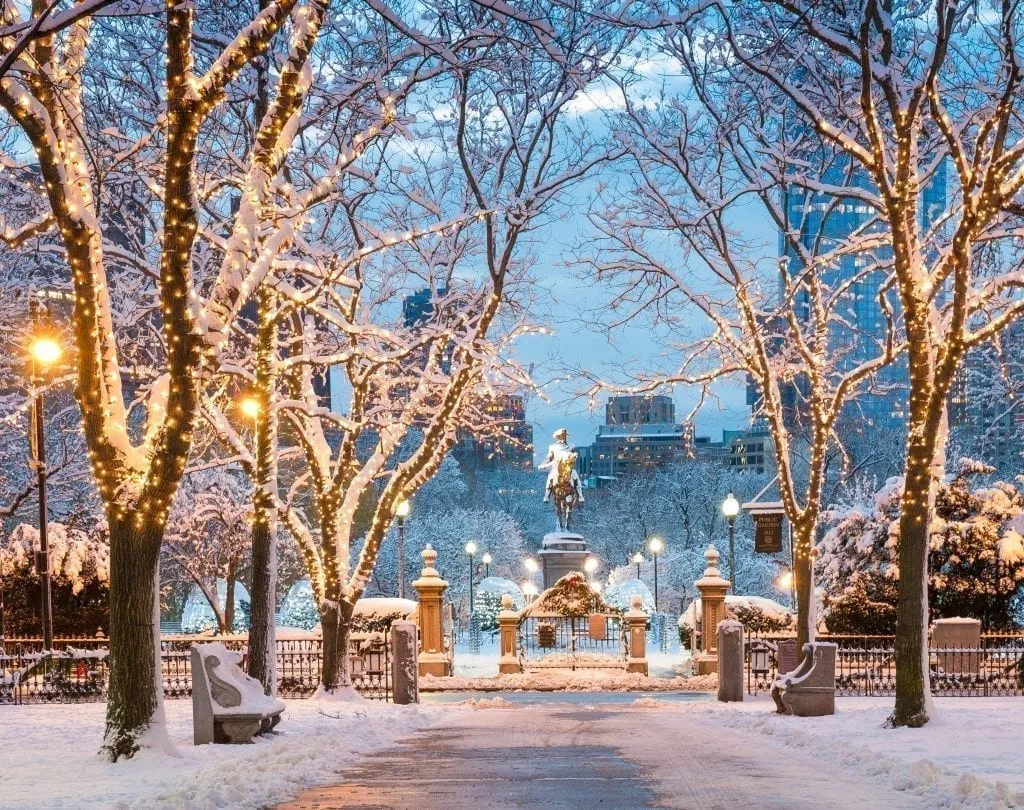 Commonwealth Avenue in Boston MA under a blanket of snow with Boston Public Garden visible in the background