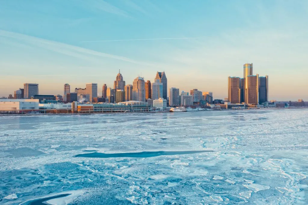 skyline of detroit michigan in winter with lake frozen over in the foreground