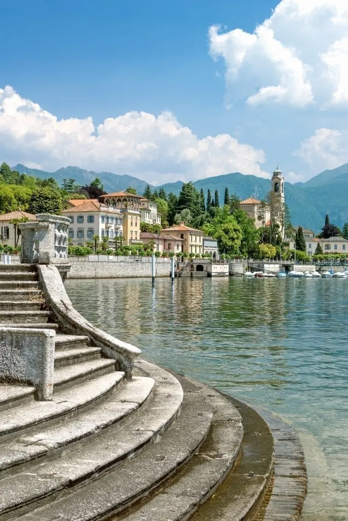 View of Lake Como with a staircase leading to the water in the foreground. Italy's lakes are part of one of the best road trips in Italy