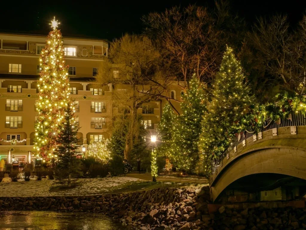 Colorado Springs decorated for the holidays with multiple Christmas trees, as seen at night