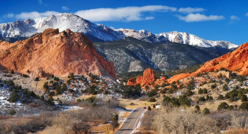 aerial view of colorado springs attractions with garden of the gods in the foreground and snowcapped pikes peak in the background