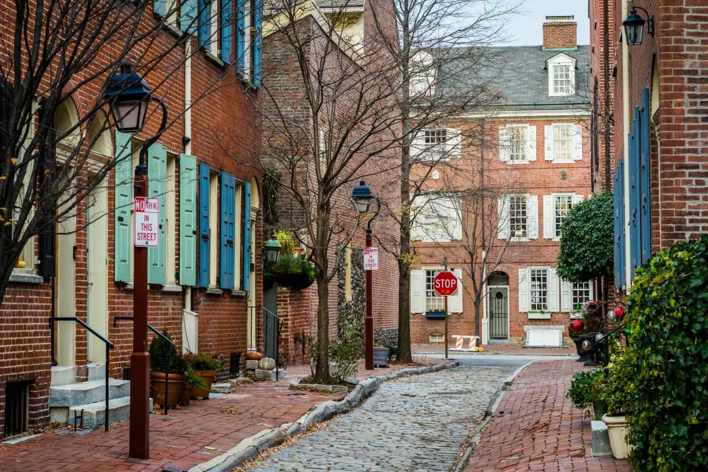 historic street in philadelphia pa in winter with cobblestone lane in the center, philly is one of the best usa december travel destinations