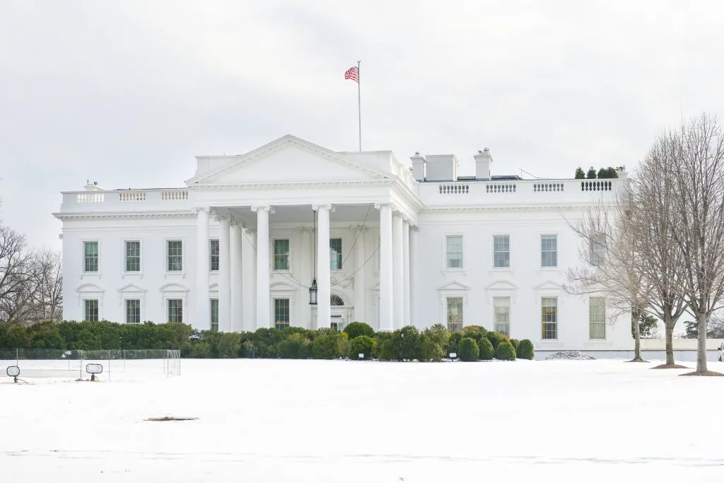 front facade of us white house with snow on the lawn in winter in usa