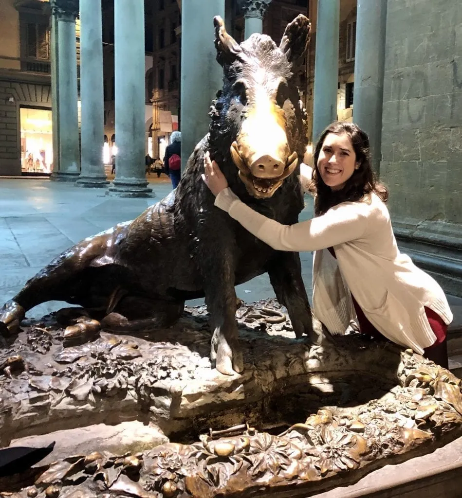 Kate Storm hugging the Porcellino statue in Florence. Checking out popular sights without the crowds is among our favorite things to do in the evening in Florence