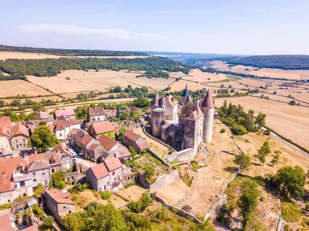 Châteauneuf-en-Auxois as seen from above, with the fortress prominent in the photo and the village spilling out to the left