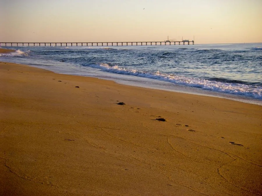 Beach of Duck North Carolina at sunset with one set of footprints in the sand. The Outer Banks of NC are some of the most beautiful beaches in the US