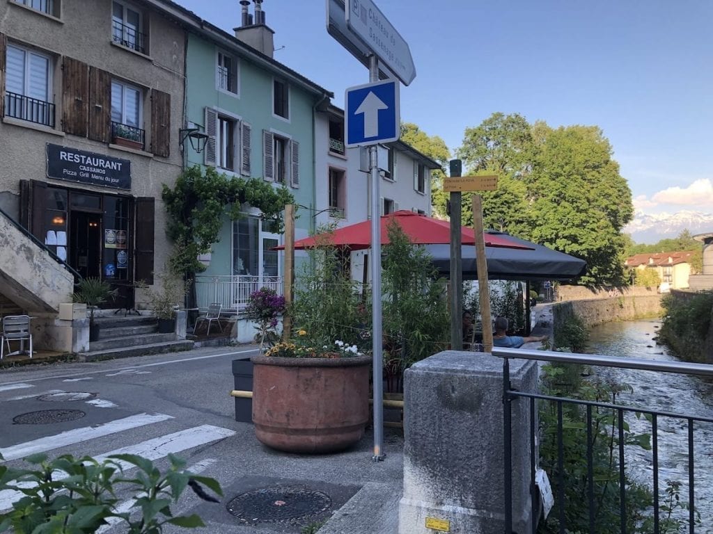 Small street in Sassenage France with a small slice of river visible to the right of the photo