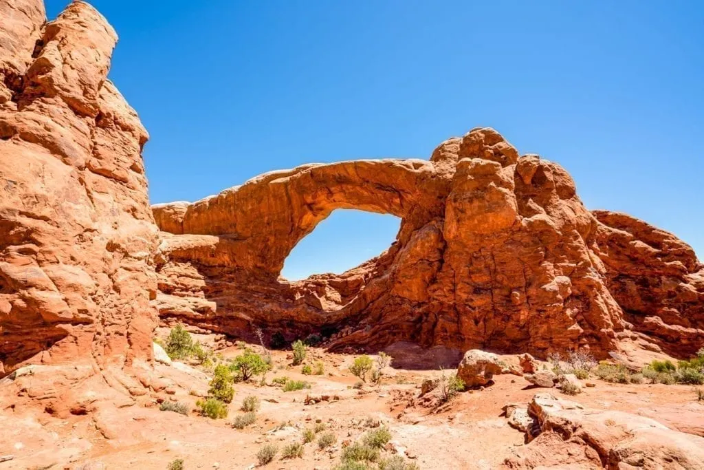 view of trail leading to an arch on a sunny day
