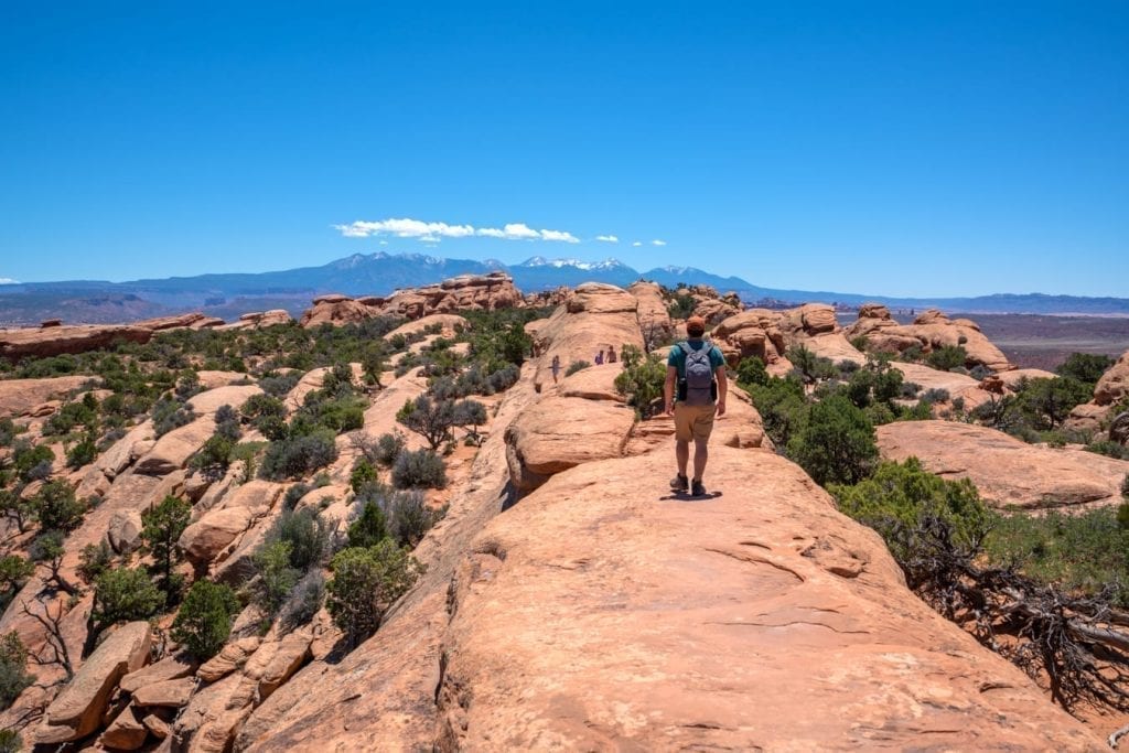 Jeremy Storm hiking along the devils garden trail, a fantastic place to visiting on a one day in arches national park itinerary