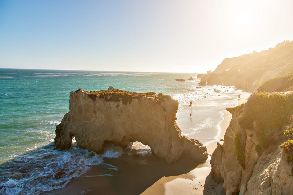 El Matador Beach in California as seen from above at golden hour, with a large rock in the center of the image