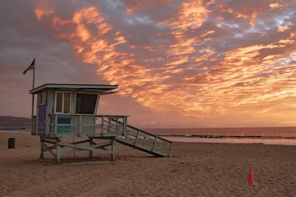 Hermosa Beach in LA at sunset with a lifeguard stand on the left side of the photo