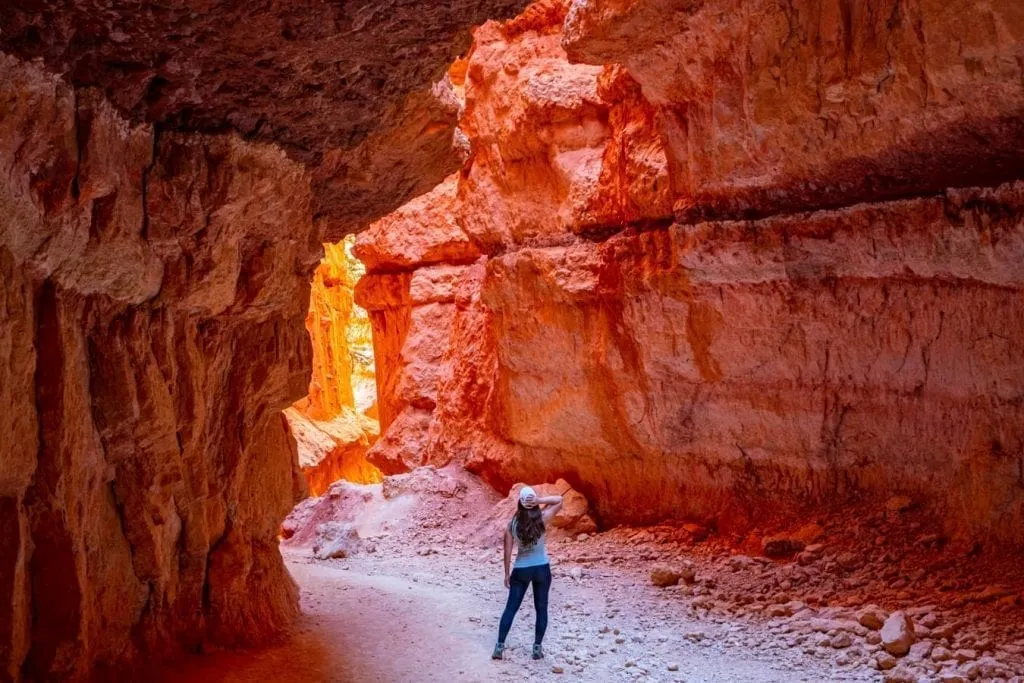 Kate Storm standing in Wall Street Bryce Canyon with her back to the camera and light reflecitng off the canyon walls