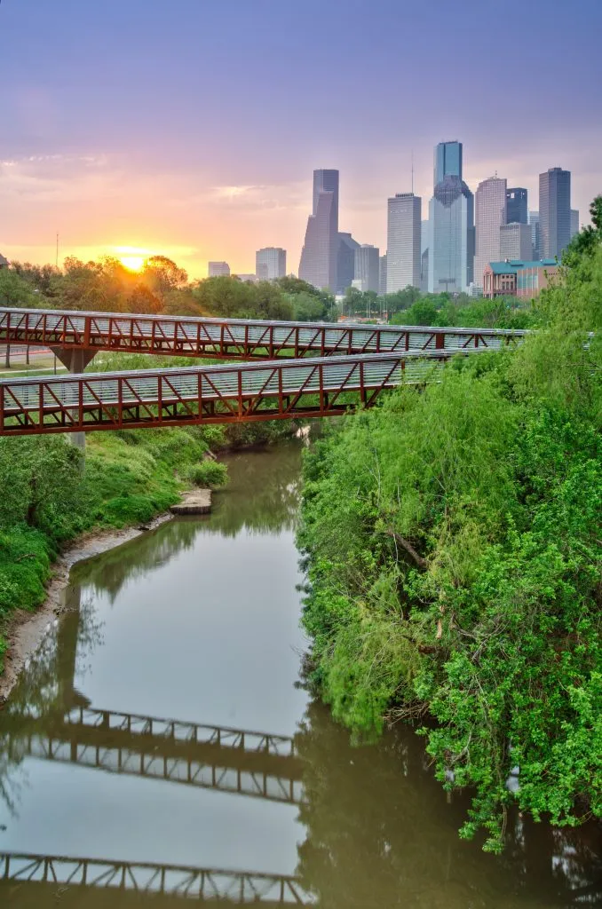 sunset over houston texas skyline with pond in the foreground, one of the unexpected places for vacation in usa