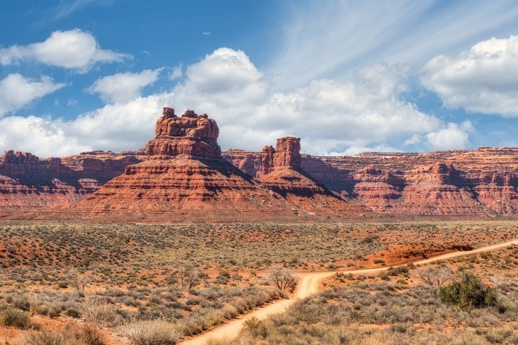 Valley of the Gods in southern Utah with a small dirt road in the foreground