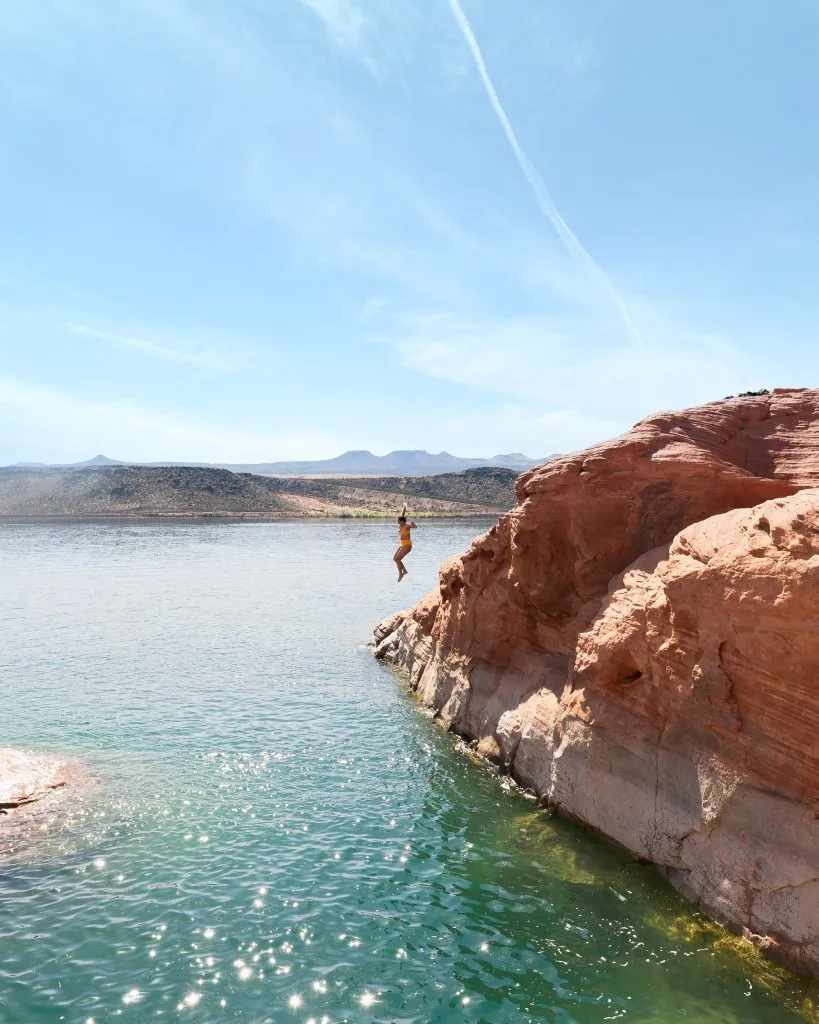 person cliff jumping into bright water at sand hollow state park, one of the most beautiful places in utah to visit