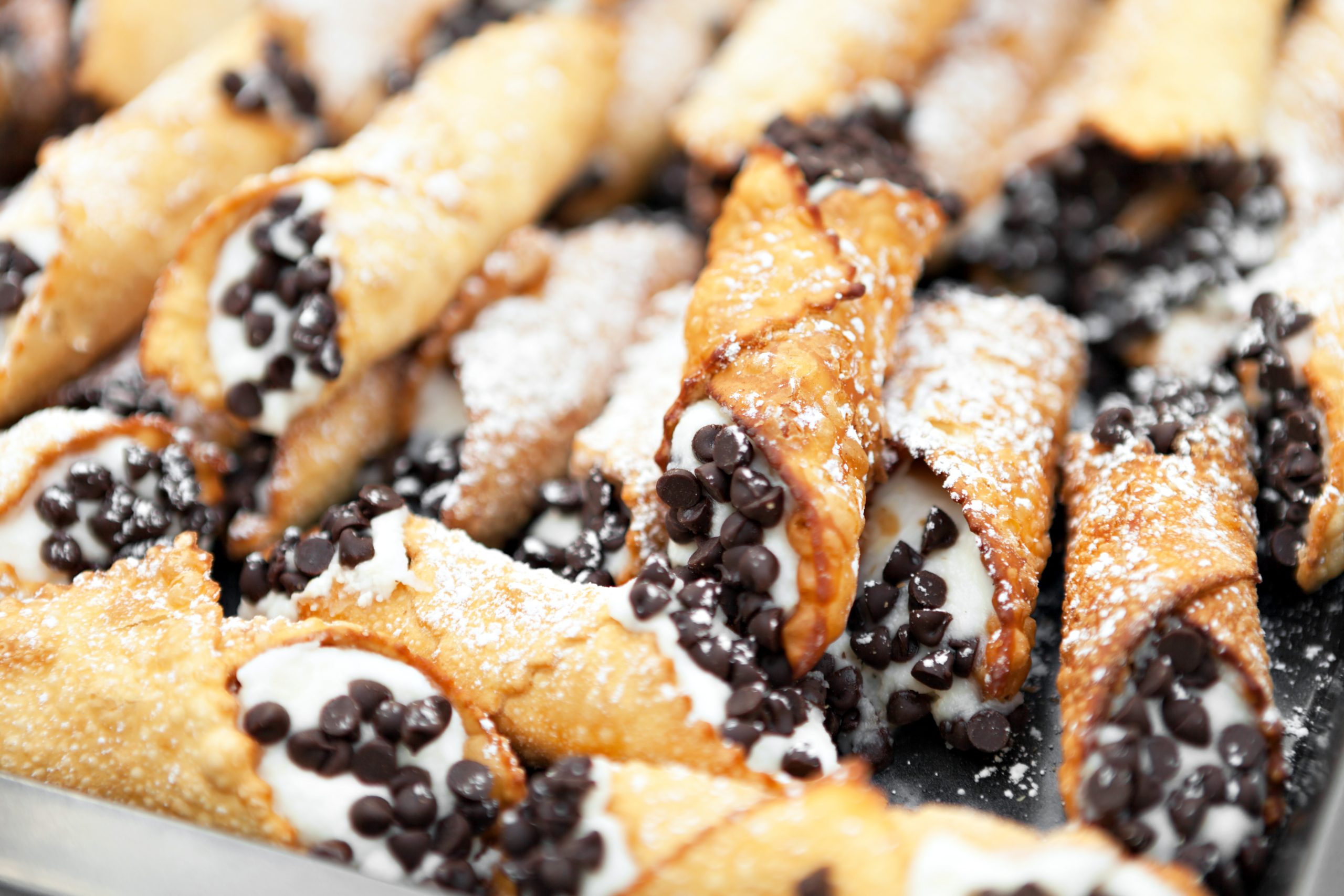 Pile of cannoli with chocolate chips on the end, one of the most popular street foods in Sicily Italy