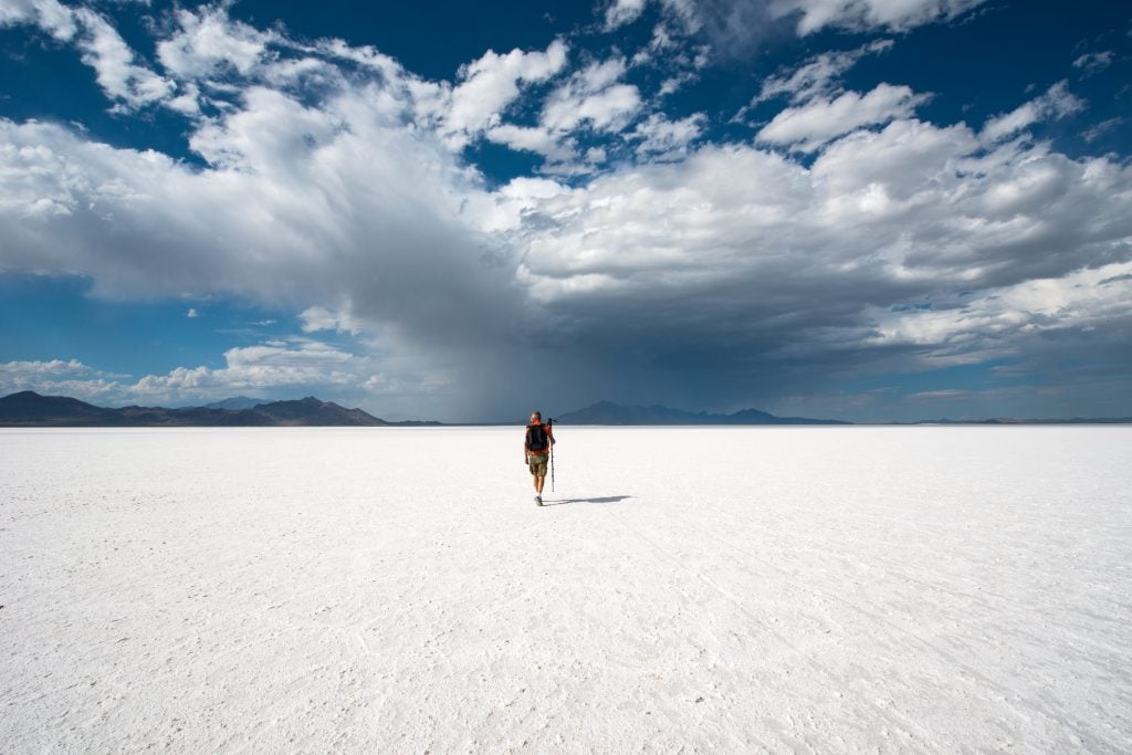 person walking across bonneville salt flats, one of the best places  in utah