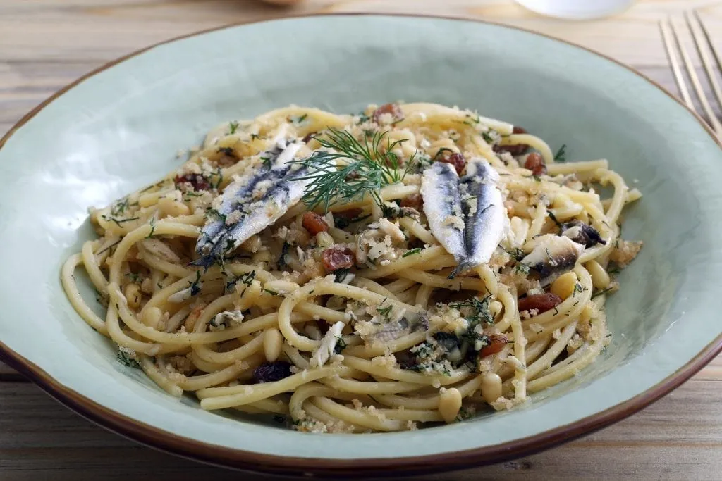 Pasta con le sarde in a light blue bowl, one of the best dishes in Sicilian cuisine