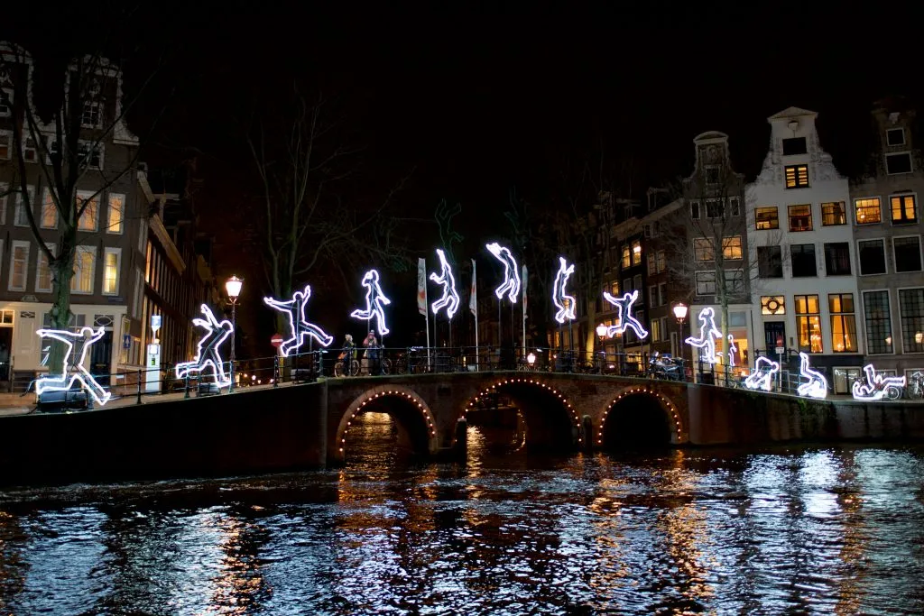 holiday light progression showing a person cartwheeling in light on a bridge in amsterdam at night