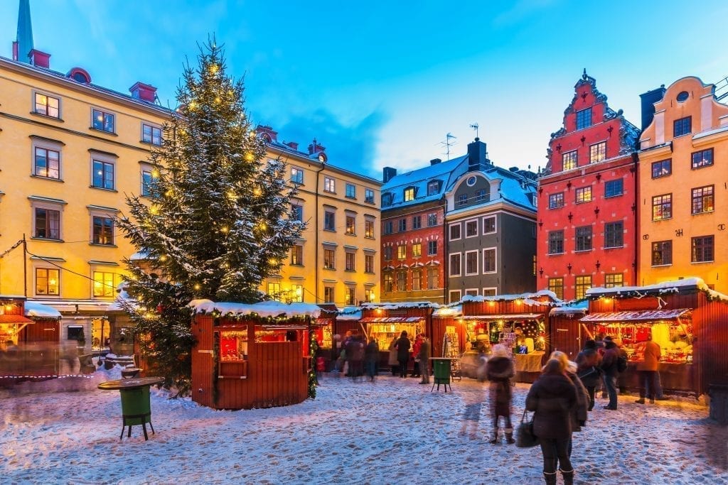 Holiday market in Gothenburg Sweden with a Christmas tree in the center and colorful buildings in the background