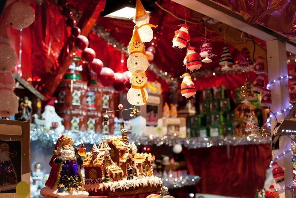 Wooden Christmas market stall selling ornaments with snowmen ornaments in the foreground