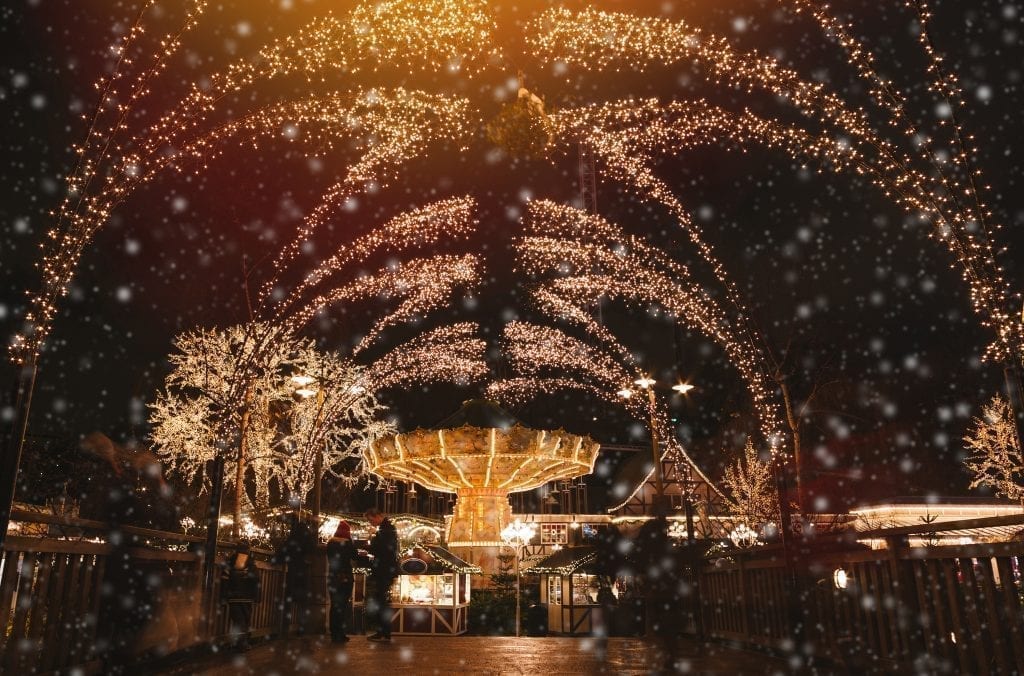 European Christmas market at Liseberg Amusement Park at night, with holiday lights framing the carousel