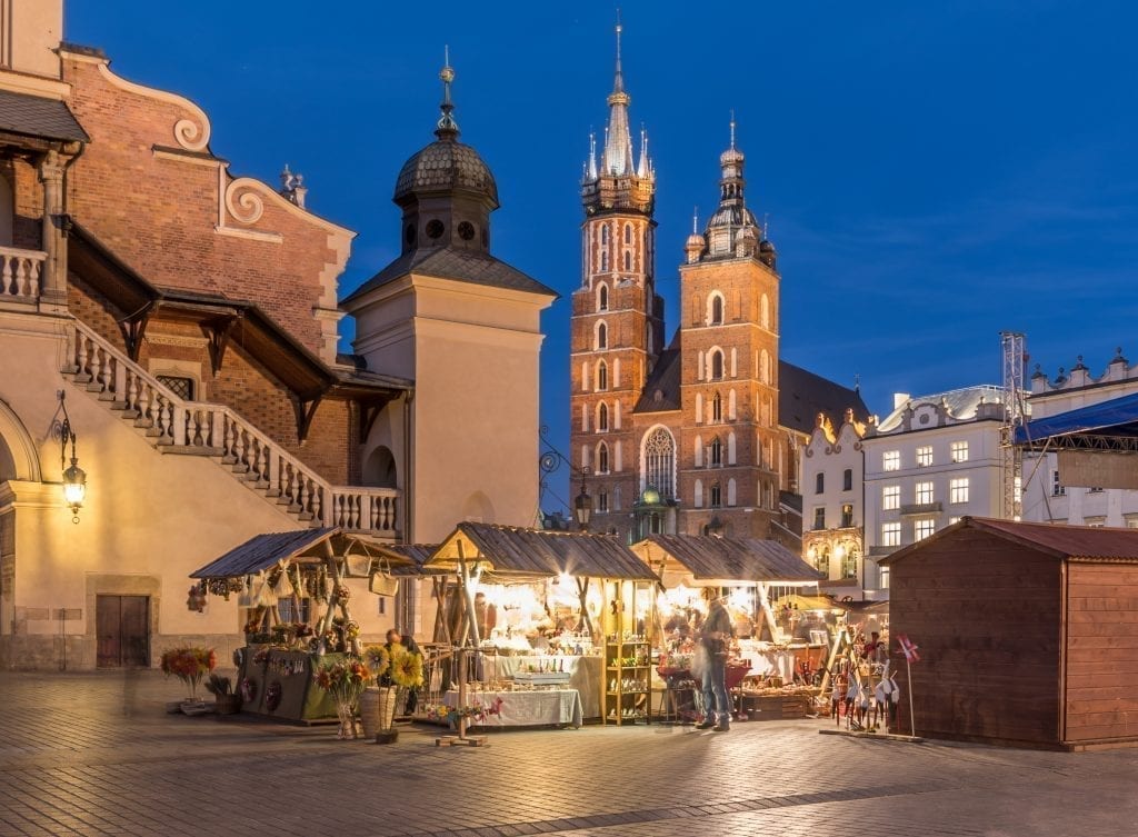 Main square of Krakow Poland at blue hour with a Christmas market open in the foreground
