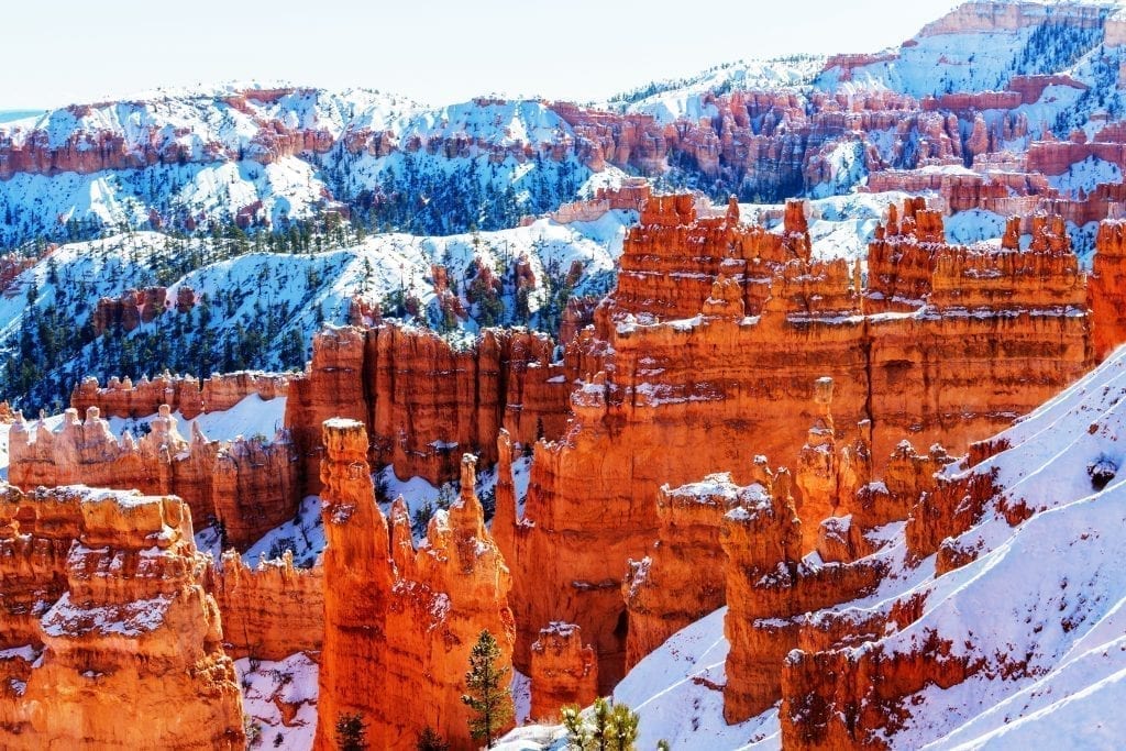View of Bryce Canyon amphitheater in winter with snow on the ground surrouding the hoodoos