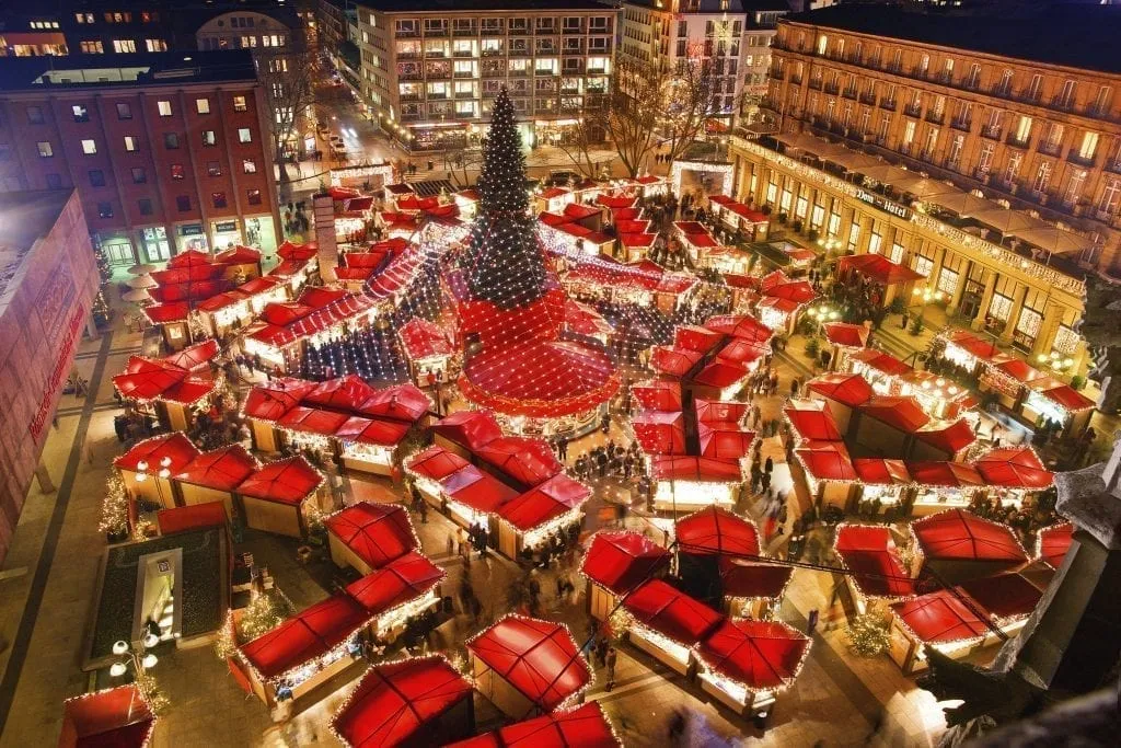 Cologne German Christmas Market at night as seen from above with red roofs of stalls prominent. Cologne hosts one of the best european christmas markets