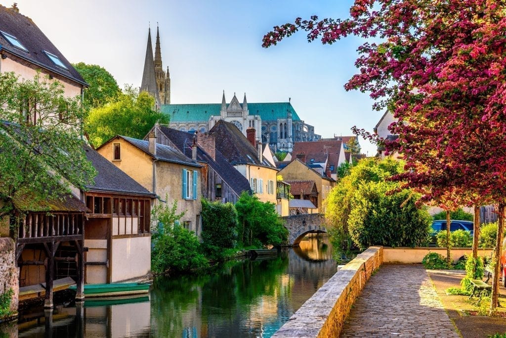 Small canal in Chartres France with half-timbered houses lining one side. Chartres is a fun Paris day trip destination