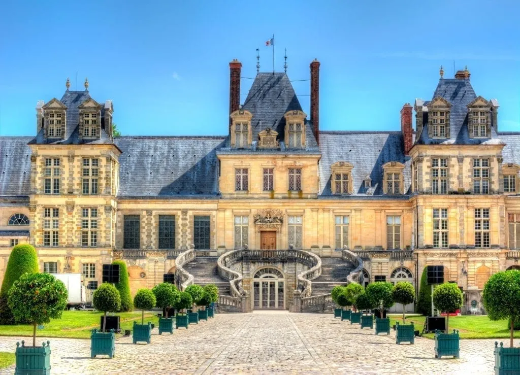 Exterior of Château de Fontainebleau as seen from the front, one of the best day trips from Paris France