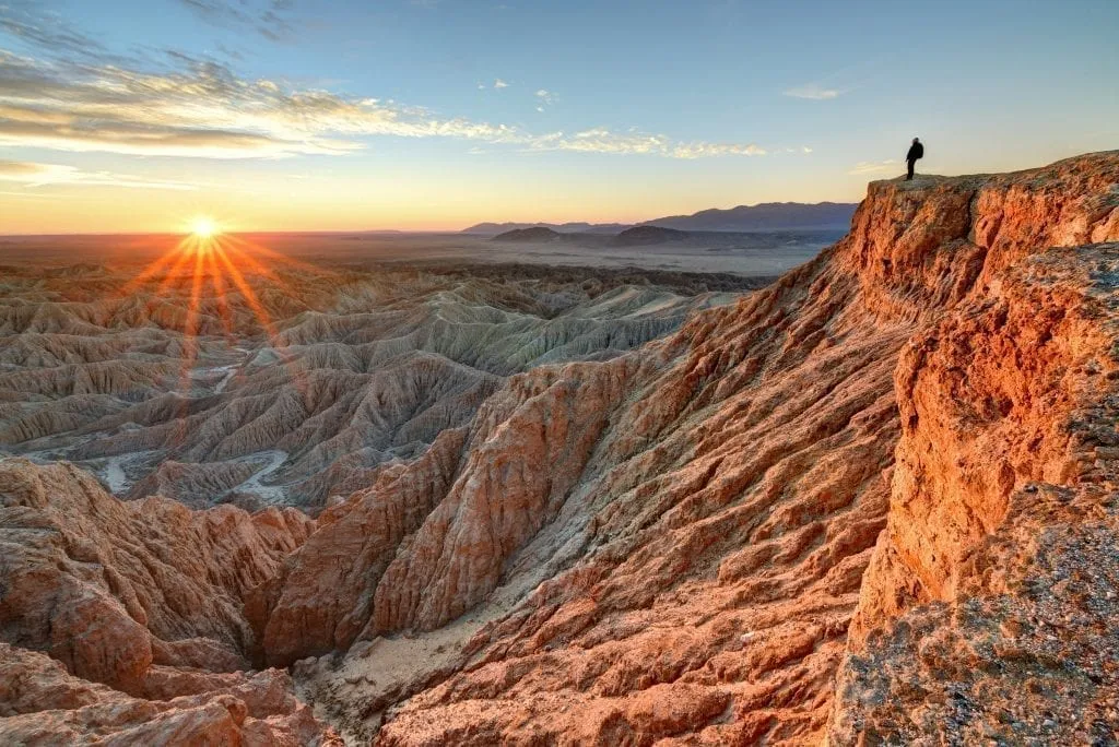 Hiker overlooking a sunrise in Anza Borrego State Park southern California, one of the best stops on a southern california road trip itinerary