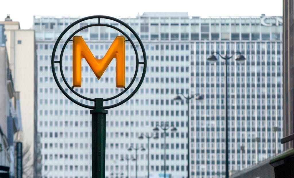 Yellow "M" sign denoting the Montparnasse-Bienvenüe metro station in Paris France