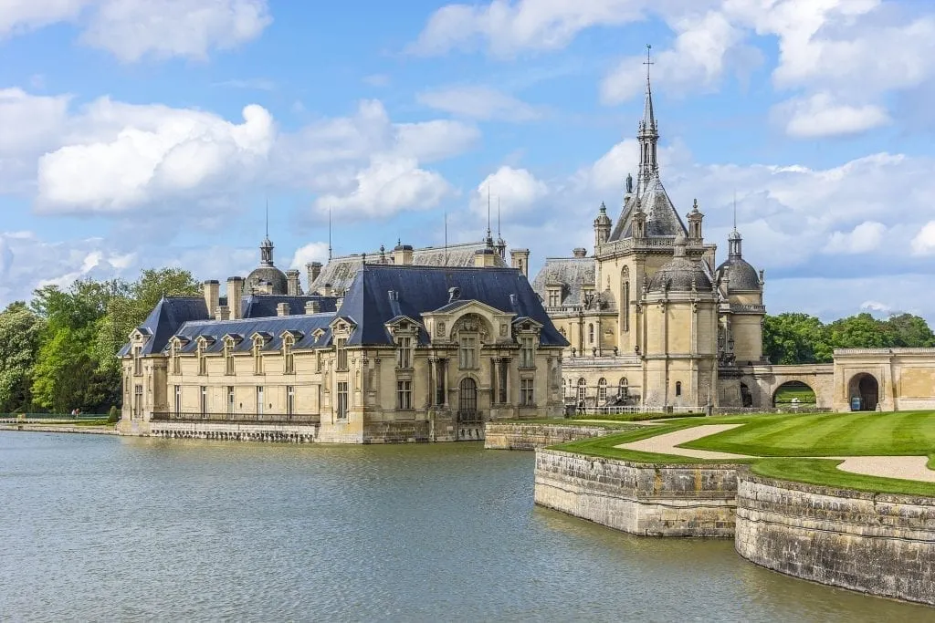 Exterior of Chateau de Chantilly as seen from across the pond, one of the best paris day trips