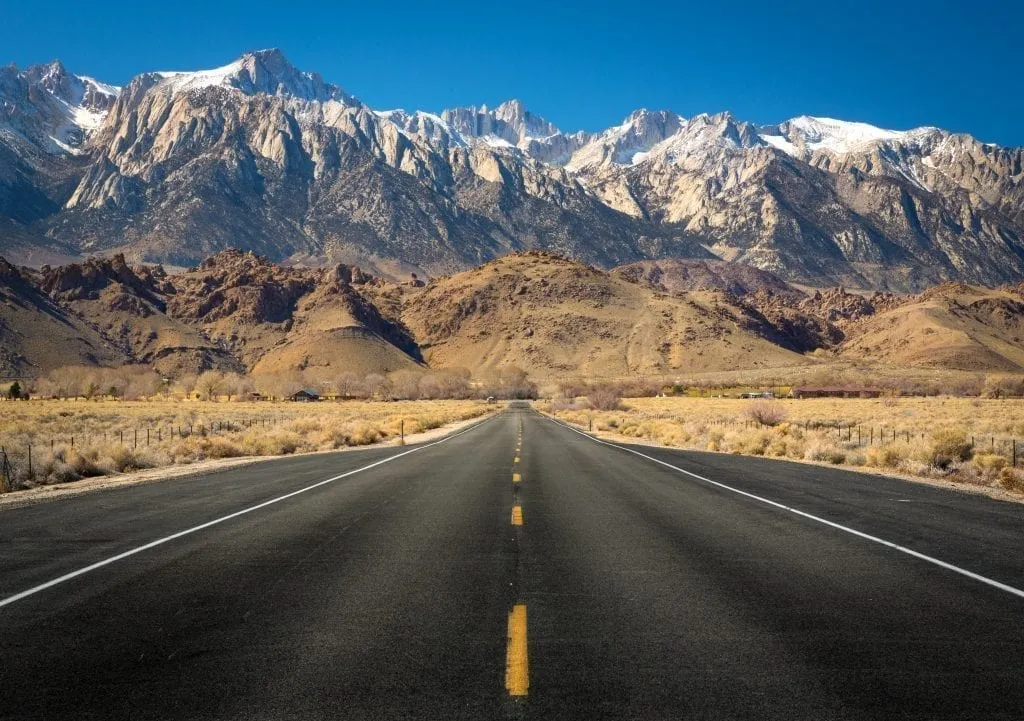 view of mount whitney with an empty road in the foreground. mount whitney is a fantastic addition to a usa west coast road trip route