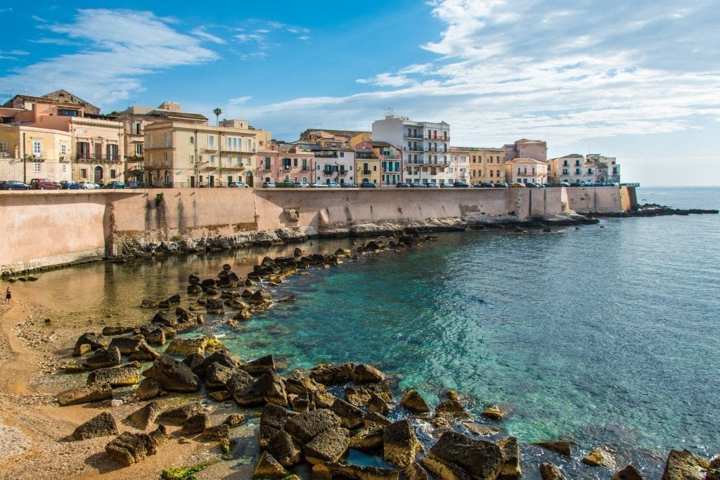 Ortigia of Siracusa Sicily as seen from the beach with the bright water in the foreground. Syracuse is one of the most beautiful places in Italy