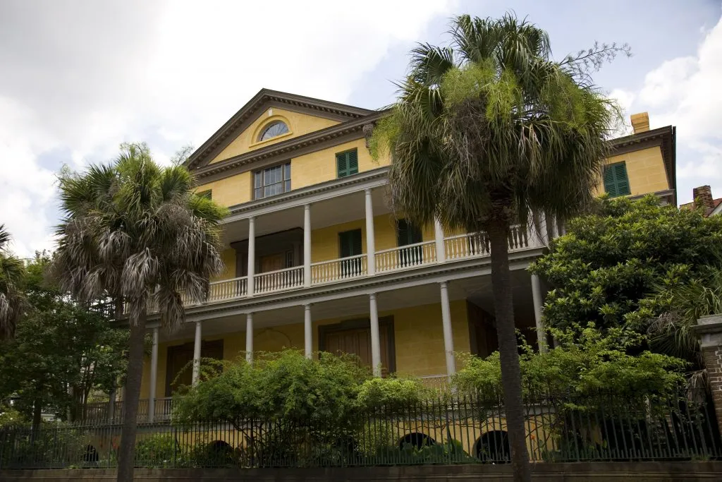 exterior of yellow aiken rhett house on a cloudy day in charleston south carolina