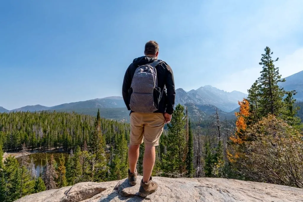 jeremy storm in a gray backpack hiking in rocky mountain national park