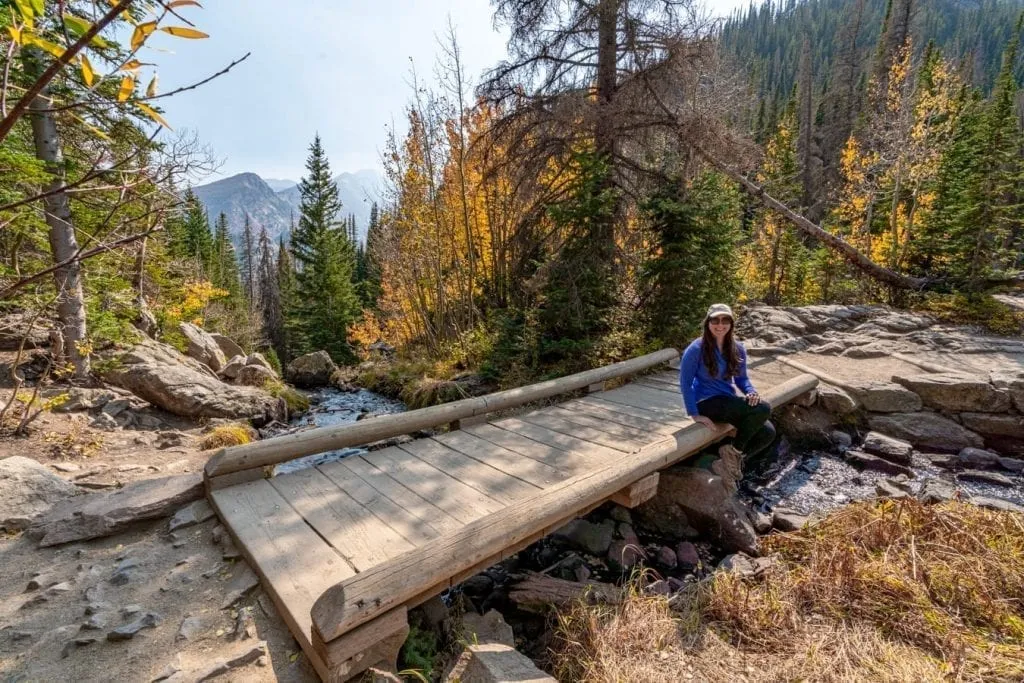 Kate Storm sitting on a wooden bridge during a hike in Rocky Mountain National Park