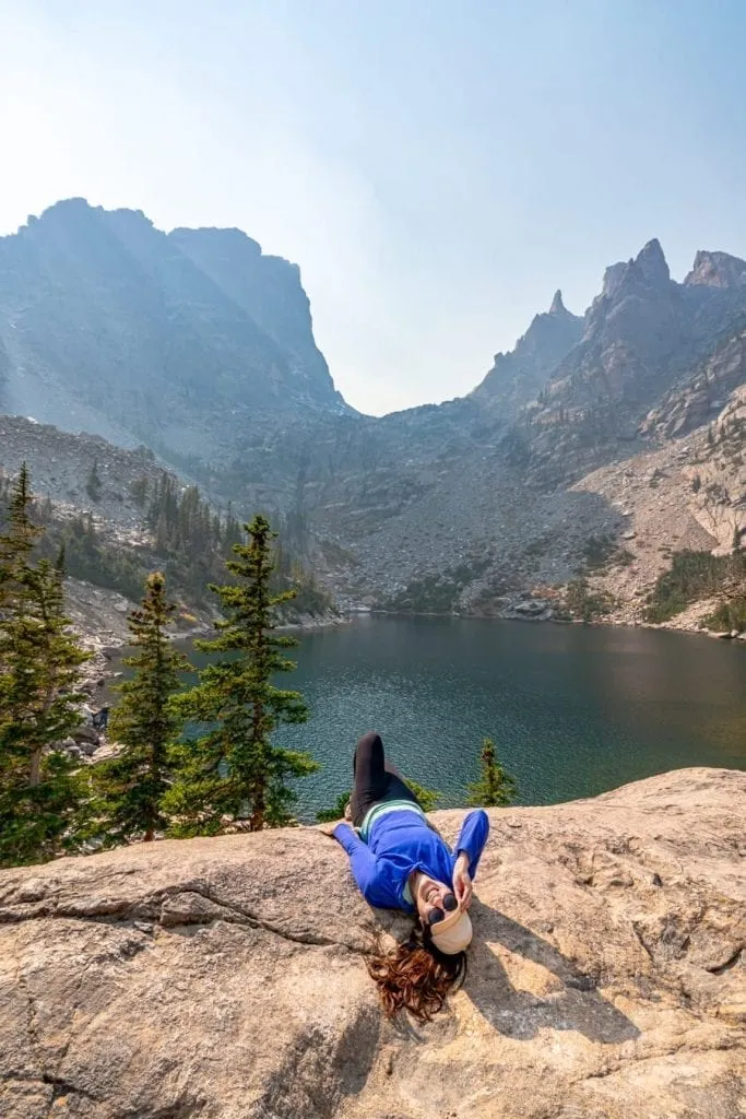 kate storm in front of emerald lake, one of the best hikes in rocky mountain national park colorado