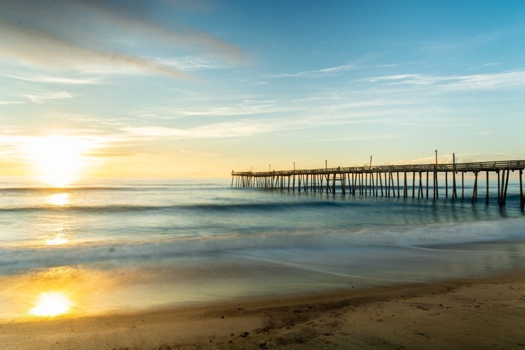 fishing pier at sunrise in rodanthe, one of the best travel destinations in north carolina for couples