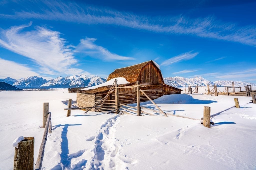 19th century barn on Mormon Row in Grand Teton National Park covered in snow. Grand Teton is one of the best national parks to visit in january december february